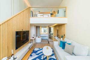 芭堤雅市中心Mila Kohlarn มิ-ลา เกาะล้าน的一间设有白色沙发和楼梯的大客厅