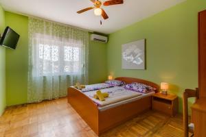 木洛希尼Rooms with a parking space Mali Losinj (Losinj) - 9681的一间卧室配有一张床和吊扇