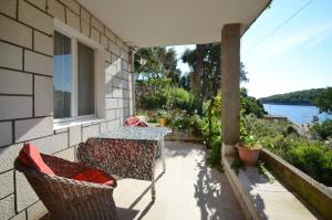 普利兹巴Apartments by the sea Grscica, Korcula - 11809的阳台配有桌椅,享有水景。