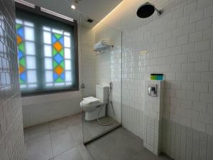 新加坡The Assembly Place, A Co-living at Mayo的一间带卫生间和彩色玻璃窗的浴室