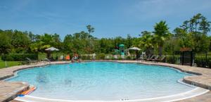 桑福德Spacious 4 Bed Home near Orlando Gated Pool Access的一个带桌椅的度假村游泳池