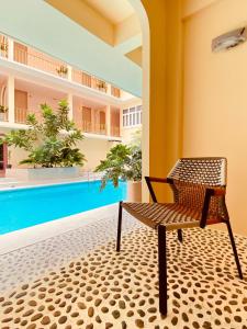 曼谷Miami Hotel Bangkok - SHA Plus的游泳池旁的椅子