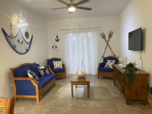 巴亚希贝Espectacular BZII, bayahibe的客厅配有蓝色椅子和电视
