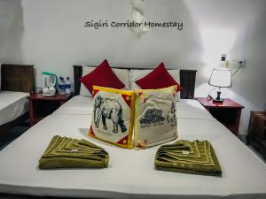 锡吉里亚Sigiri Corridor Home Stay的一张带两条毛巾和两个枕头的床