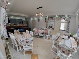 锡纳亚Pensiunea Nicolas的用餐室配有白色的桌子和白色的椅子