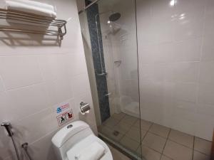 伊纳南TD CAPITAL HOTEL的一间带卫生间和玻璃淋浴间的浴室