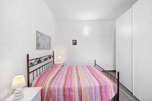阿拉西奥La Colombera的白色卧室,配有带条纹毯子的床