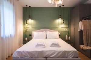 法拉-迪索利戈AL TIGLIO的一间卧室配有一张白色床和绿色床头板
