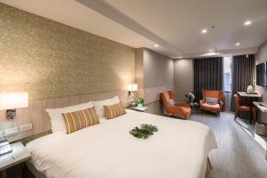 台北珂曼旅馆的酒店客房设有一张大床和一张书桌。