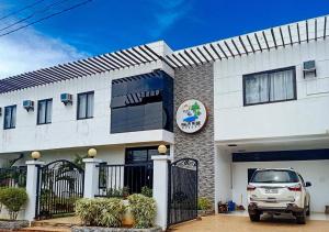 邦劳RedDoorz Plus at Palm Rise K Diving Resort Panglao Bohol的前面有一辆汽车停放的白色房子