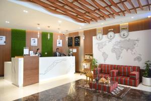 迪拜Smana Hotel Al Raffa的大堂设有前台,墙上挂有世界地图