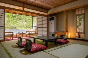 日光Nikko Nationalpark Kawamata Onsen KURA的客房设有桌椅和窗户。