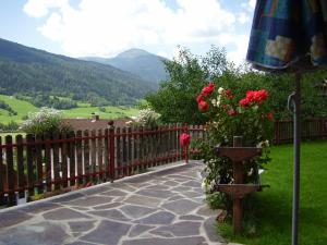 Ranten莫泽住宿加早餐旅馆的庭院设有围栏、鲜花和雨伞。