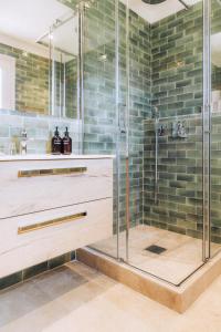 圣特罗佩杜苏德家园酒店的浴室铺有绿色瓷砖,设有淋浴。