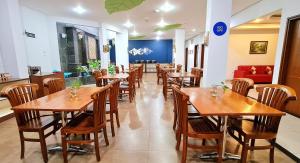 万隆达法姆里奥酒店的用餐室配有木桌和椅子