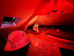 Douchy-les-MinesRedroom Loveroom Chambre Spa privative Insolite Thème 50 nuances de grey的红色的房间,配有浴缸和带蜡烛的床