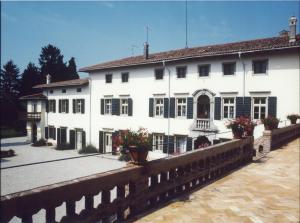 ToglianoVolpe Pasini - Wine and Rooms的一座白色的大建筑,前面有鲜花