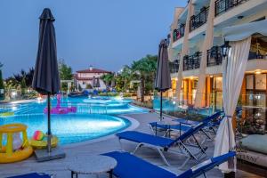 索佐波尔Cristiani Hotel Sozopol的酒店旁的游泳池配有椅子和遮阳伞