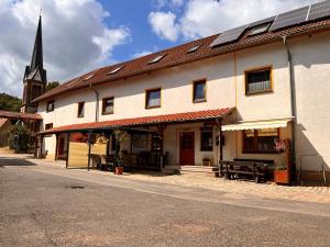 HörschelPension "Tor zum Rennsteig"的一座建筑的侧面设有太阳能电池板