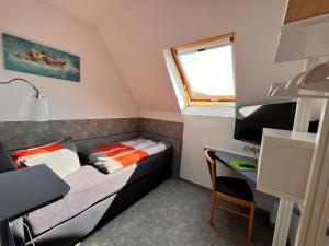 HörschelPension "Tor zum Rennsteig"的小房间设有一张床和一张书桌