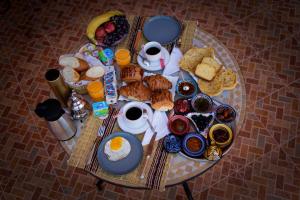 瓦尔扎扎特Riad Parfums de OUARZAZATE的一张桌子,上面有早餐食品和饮料