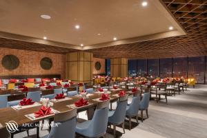 绥和市Mandala Hotel & Spa Phú Yên的大型用餐室配有桌椅