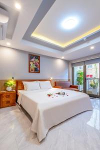 岘港Mina Home Đà Nẵng的卧室设有一张白色大床和一扇窗户。