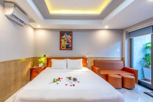 岘港Mina Home Đà Nẵng的配有一张床和一把椅子的酒店客房
