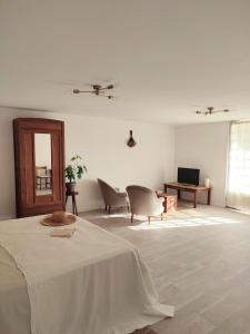 乌瑞基尼Maison Caiada的白色的客房配有床、椅子和电视。