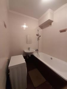 乌日霍罗德Lux na Osipenko的白色的浴室设有浴缸和水槽。