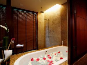 奥南海滩Centara Grand Beach Resort & Villas Krabi的浴室配有鲜花盛开的浴缸。