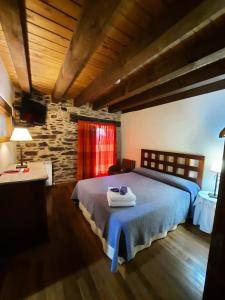 普韦布拉桑纳比亚橡树叶乡村民宿的一间卧室设有一张大床和石墙