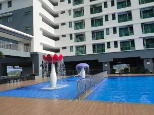 加影Nur Mateen's Studio - Vista Bangi Service Apartment的一座建筑前的游泳池,设有两个喷泉
