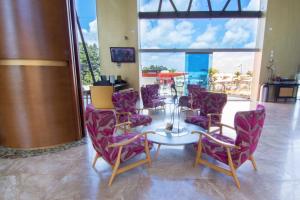 佩雷拉佩雷拉索尼斯塔酒店的一间用餐室,配有紫色椅子、一张桌子和一扇窗户