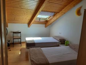 贝瑙卡斯El Mirador de la Sierra的一间卧室设有两张床,天花板上设有天窗。
