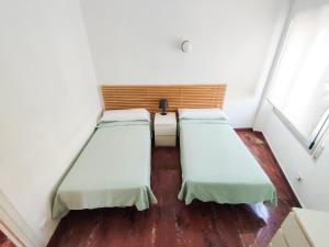 坎布里尔斯Villa Fortuni Mexico I的铺有木地板的小客房内的两张床