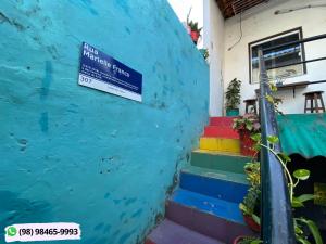 圣路易斯Guarnicê Hostel的房屋边有五颜六色台阶的标志