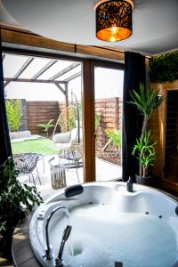 塞格德Meru Minivilla的窗户前的浴缸,带庭院