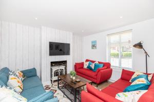 SwayWestview Cottage bikes/chef/hot tub的客厅设有红色和蓝色的沙发和壁炉