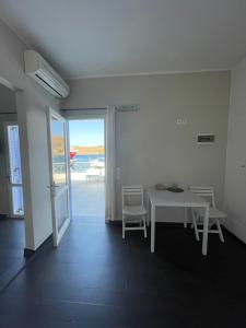 科里夏AEGEAN VIEW SEASIDE ROOMS AND STUDIOS KEA的海景客房内的白色桌椅