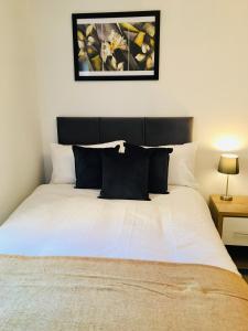 沃金Cloud9SA at Woking Central的卧室内的一张带黑白枕头的床
