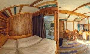 迪利然Cozy House的卧室配有一张床铺,位于带木墙的房间内