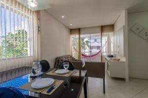 萨尔瓦多2 Quartos Varanda Piscina, 300 m praia Wi-Fi 200Mb的一间带桌椅的客厅和一间厨房