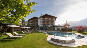 梅拉诺伯格拉弗勒尔霍夫酒店的一个带游泳池和椅子的度假胜地和一座建筑