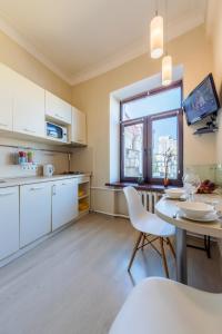 基辅Однокімнатні апартаменти на Майдані, дистанційне заселення 24х7的厨房配有白色橱柜、桌子和窗户。