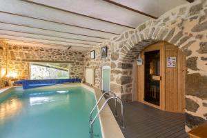 佩吕桑乐贝特奥酒店的一座石墙房子内的游泳池