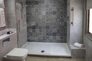 诺丁汉华美达诺丁汉市中心酒店的带浴缸、卫生间和淋浴的浴室。