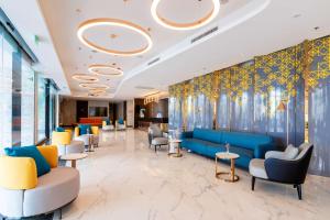 曼谷Best Western Nada Don Mueang Airport hotel的一间配备有蓝色沙发和椅子的等候室