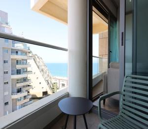 特拉维夫West Tel Aviv- All Suites Hotel By The Sea的阳台配有椅子,享有海景