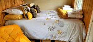巴尔马卡拉Cozy Shepherd hut 20 by 7 feet with boxed in high double bed的一间卧室配有一张带白色毯子和枕头的床。